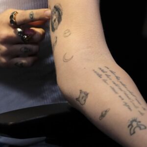 Miley’s unreadable text on inner arm.